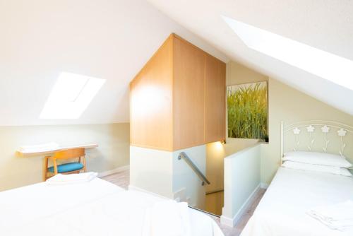 Schlafzimmer im Dachgeschoss mit 2 Betten und einem Schrank in der Unterkunft Apartamentos Go - Chalet Calera in Arroyo de la Encomienda