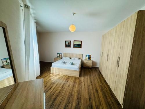 a bedroom with a bed and a wooden floor at Apartamente Tirana in Tirana