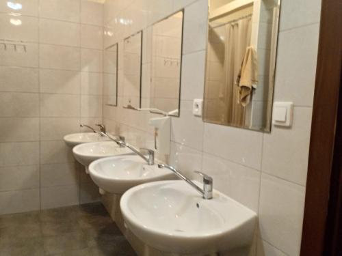 a row of sinks in a bathroom with mirrors at Lubelski in Warsaw