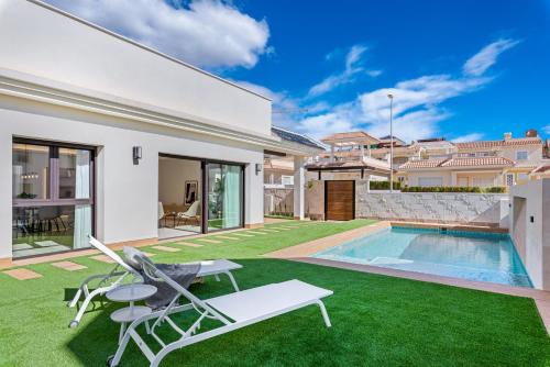 ein Haus mit Pool und Rasen in der Unterkunft Villa Tortuga Blanca, Ciudad Quesada, Costa Blanca in Ciudad Quesada