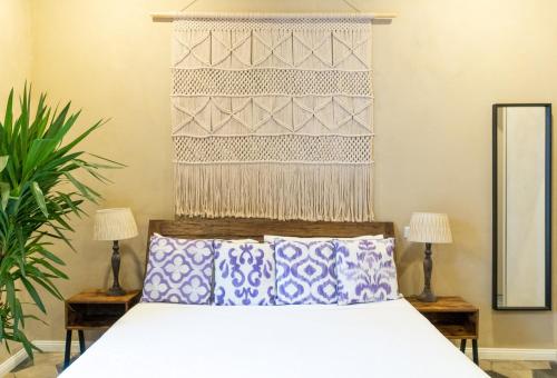 a bedroom with a bed with a headboard and two lamps at HOPESTEL Secret Garden Napoli in Naples