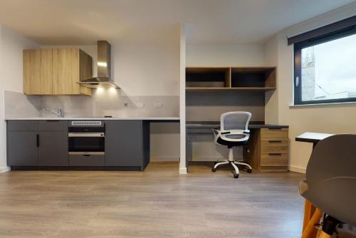 a kitchen with a desk and a chair in a room at Canvas Wembley in London in London