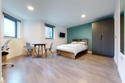 a bedroom with a bed and a table and chairs at Private Bedrooms with Shared Kitchen, Studios and Apartments at Canvas Wembley in London in London