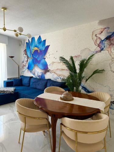 un salon avec un canapé bleu, une table et des chaises dans l'établissement L'appartement Azur, à Nice