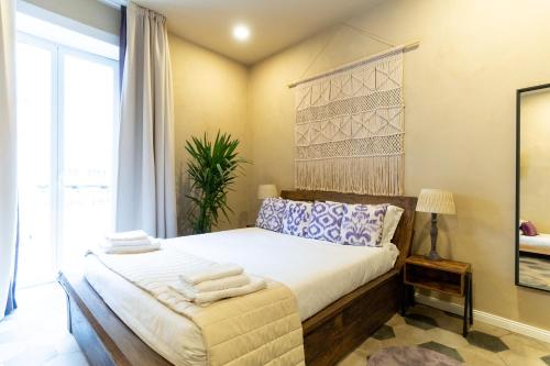 a bedroom with a bed with towels on it at HOPESTEL Secret Garden Napoli in Naples