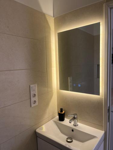 a bathroom with a sink and a mirror at Luca Apartman in Gyenesdiás
