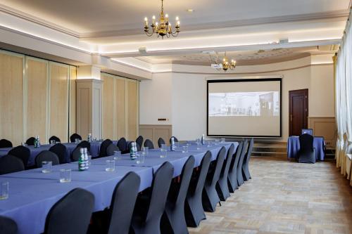 a conference room with tables and chairs and a screen at Hotel Cristal Park in Dąbrowa Tarnowska