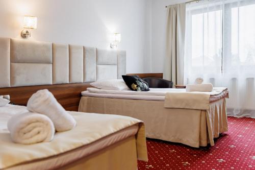 a hotel room with two beds with towels at Hotel Cristal Park in Dąbrowa Tarnowska