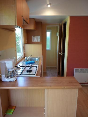 a kitchen with a sink and a stove top oven at Camping Les Rives du Céou in Saint-Chamarand