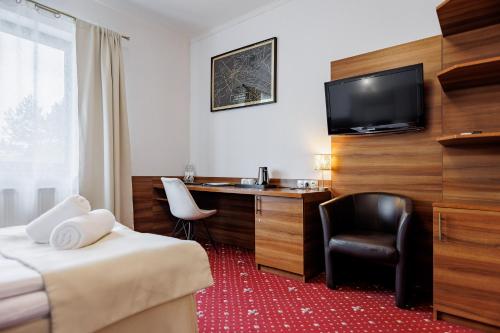 a hotel room with a desk and a television at Hotel Cristal Park in Dąbrowa Tarnowska