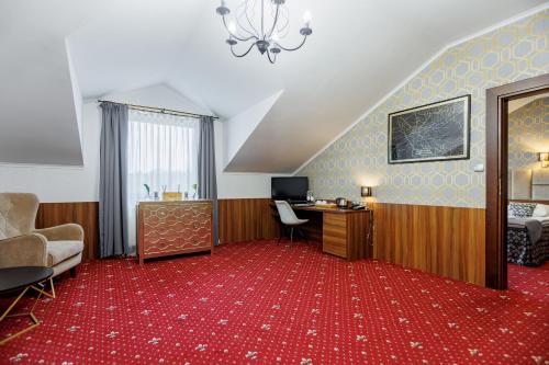 a hotel room with a desk and a red carpet at Hotel Cristal Park in Dąbrowa Tarnowska