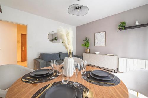 une salle à manger avec une table, des assiettes et des verres dans l'établissement Place d'Erlon Hyper Centre, à Reims