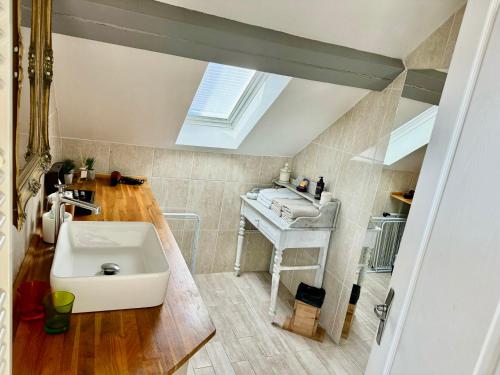 a bathroom with a sink and a skylight at Le Relais des Ducs : centre historique Dijon in Dijon