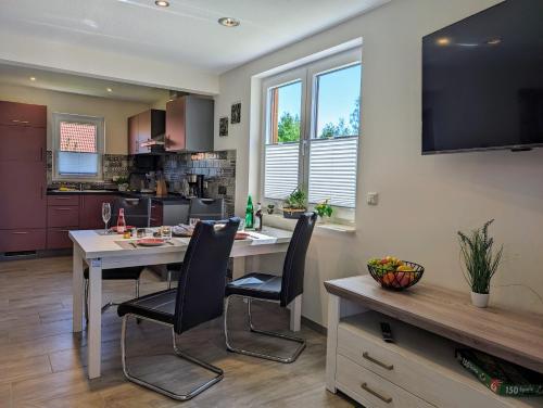 a kitchen and dining room with a table and chairs at Premiumferienhaus Mara in Hasselfelde