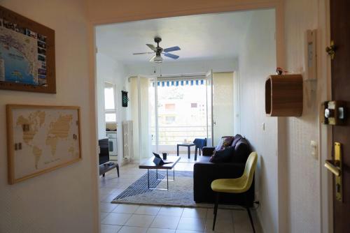 a living room with a couch and a ceiling fan at Cannes Studio near Croisette Plage in Cannes