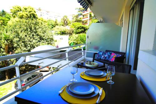 a table with plates and wine glasses on a balcony at Cannes Studio near Croisette Plage in Cannes