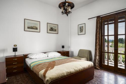 una camera da letto con un letto, una sedia e una finestra di Aurora Beach House a Sidari