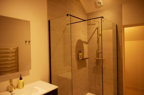 um chuveiro com uma porta de vidro na casa de banho em The Old Winery Cottage No1 em Shepton Mallet