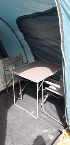 a table and a chair in a tent at Agricampeggio Cà di Mazza in Monzuno