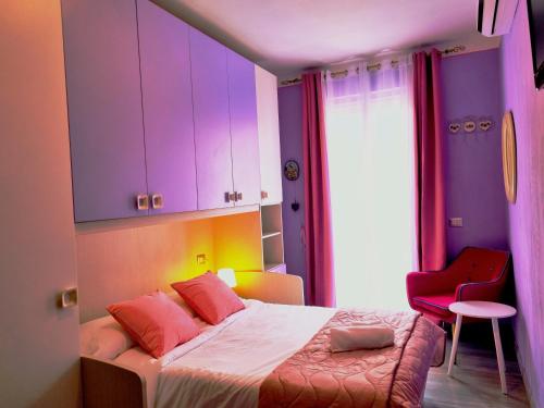 1 dormitorio con 1 cama con armarios morados y silla roja en Sweet Dream, en Passignano sul Trasimeno