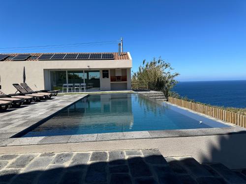 una piscina con vistas al océano en João de Oliveira casas de campo, en Santo António