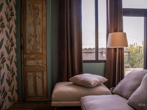 a bedroom with a bed and a lamp and a window at Charmant T1 calme et reposant in Saint-Andiol