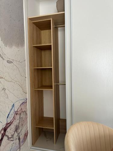 un placard avec des étagères en bois et une chaise dans l'établissement L'appartement Azur, à Nice