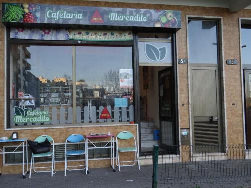 a store with chairs and tables in front of a window at Be Local - Apartment with 2 bedrooms in Infantado in Loures in Loures
