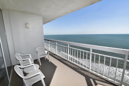 a balcony with two chairs and the ocean at 1412 Waters Edge Resort condo in Myrtle Beach