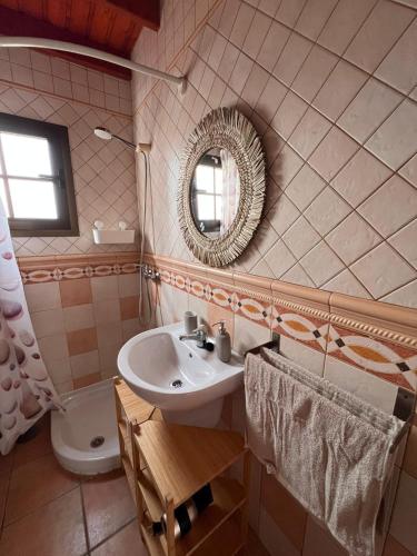 Un baño con lavabo, espejo e inodoro. en Casa Volcán, en La Costa