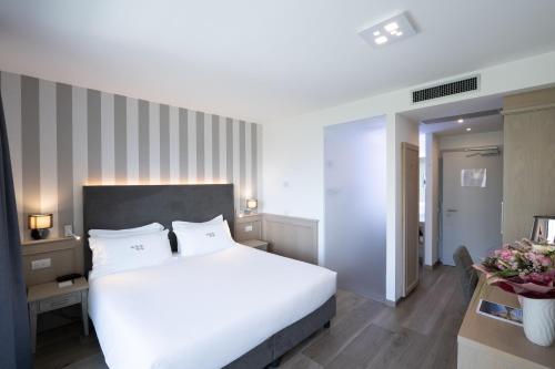a bedroom with a large white bed in a room at Hotel Bellariva in Riva del Garda