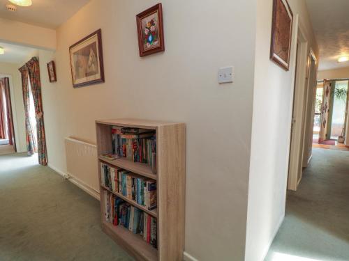 a book shelf filled with books in a hallway at Plummers Water in Lymington