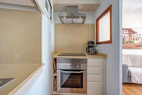 a small kitchen with a stove in a tiny house at Chalet Cal Tio Miquel by dracmallorca in Cala Santanyi