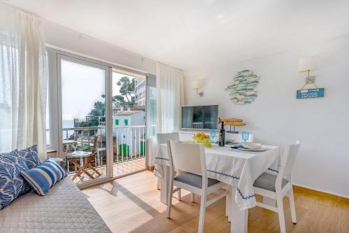 a dining room with a white table and chairs at Chalet Cal Tio Miquel by dracmallorca in Cala Santanyi