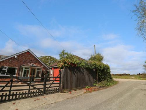 a house with a fence in front of a street at Plummers Water in Lymington