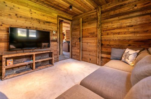 - un salon avec une télévision dans une cabane en rondins dans l'établissement Chalet Eagle - LES GETS, à côté du lac et des pistes, superbe vue, aux Gets
