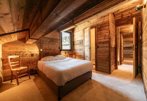 une chambre avec un lit et un mur en bois dans l'établissement Chalet Eagle - LES GETS, à côté du lac et des pistes, superbe vue, aux Gets