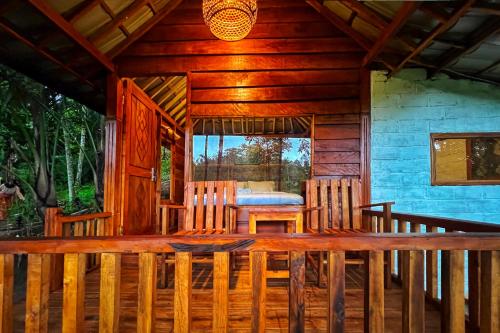 a porch of a wooden cabin with a table and chairs at Aulia Bungalows in Tetebatu