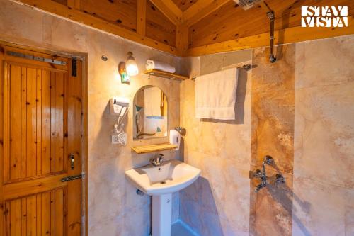 une salle de bain avec un lavabo et un miroir dans l'établissement StayVista at Maryam Cottage - Pet-friendly Villa with Alfresco Dining, BBQ, Bonfire, à Pahalgām