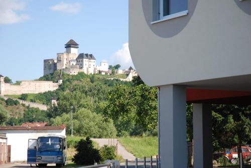Ein blauer Truck fährt mit einem Schloss die Straße hinunter. in der Unterkunft Penzion Royal in Trenčín
