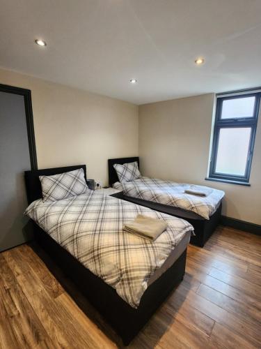 a bedroom with two beds and a window at 133B PARK ROAD STRETFORD MANCHESTER in Manchester