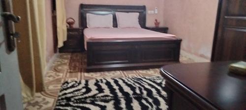1 dormitorio con 1 cama con alfombra blanca y negra en Igrane House en Marrakech