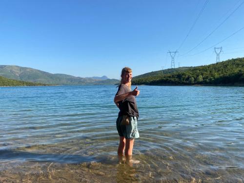 a woman standing in the water in the water at Camping Lisna in Vau i Dejës
