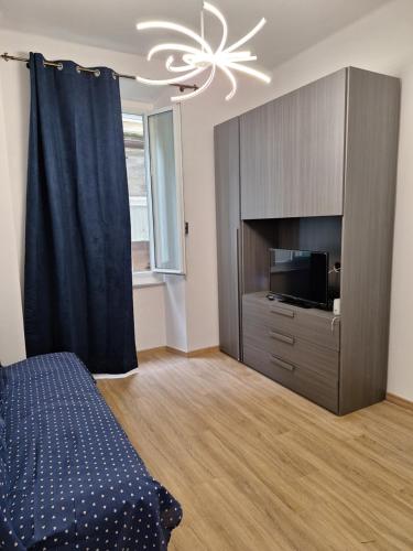 Un dormitorio con una cama, un televisor y una lámpara de araña. en La Perla del Porto Antico, en Génova