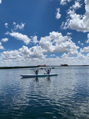 two people are on a boat in the water at Titicaca Magical Lodge Peru in Puno