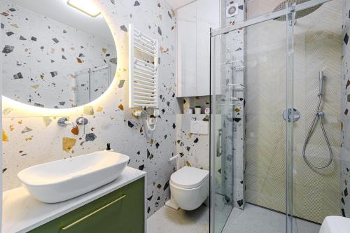 a bathroom with a toilet sink and a shower at Szum Fal Rewal in Rewal