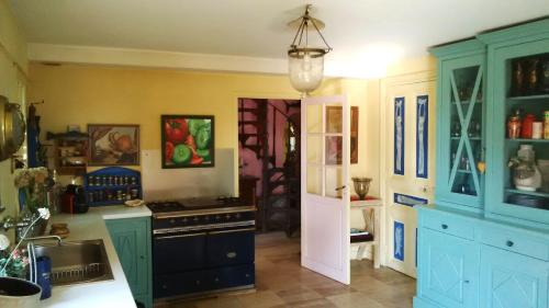 - une cuisine avec des placards bleus et une cuisinière noire dans l'établissement Villa Kerguénolé, à Bangor