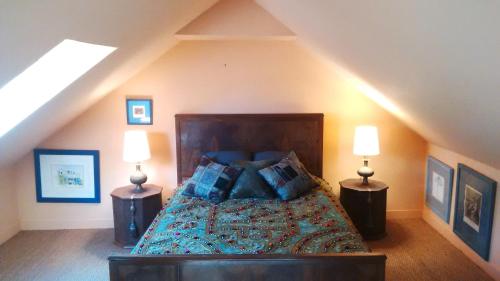 um quarto com uma cama grande e 2 candeeiros em Villa Kerguénolé em Bangor