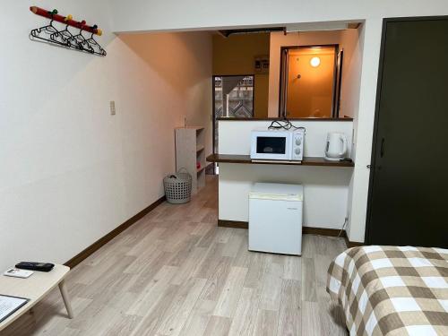 a small room with a kitchen with a microwave at アルピエf 103号室 無料WiFiあります生活しやすい場所です in Kumamoto