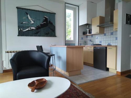 une cuisine avec une table et une chaise noire dans l'établissement Studio Baulois, à La Baule